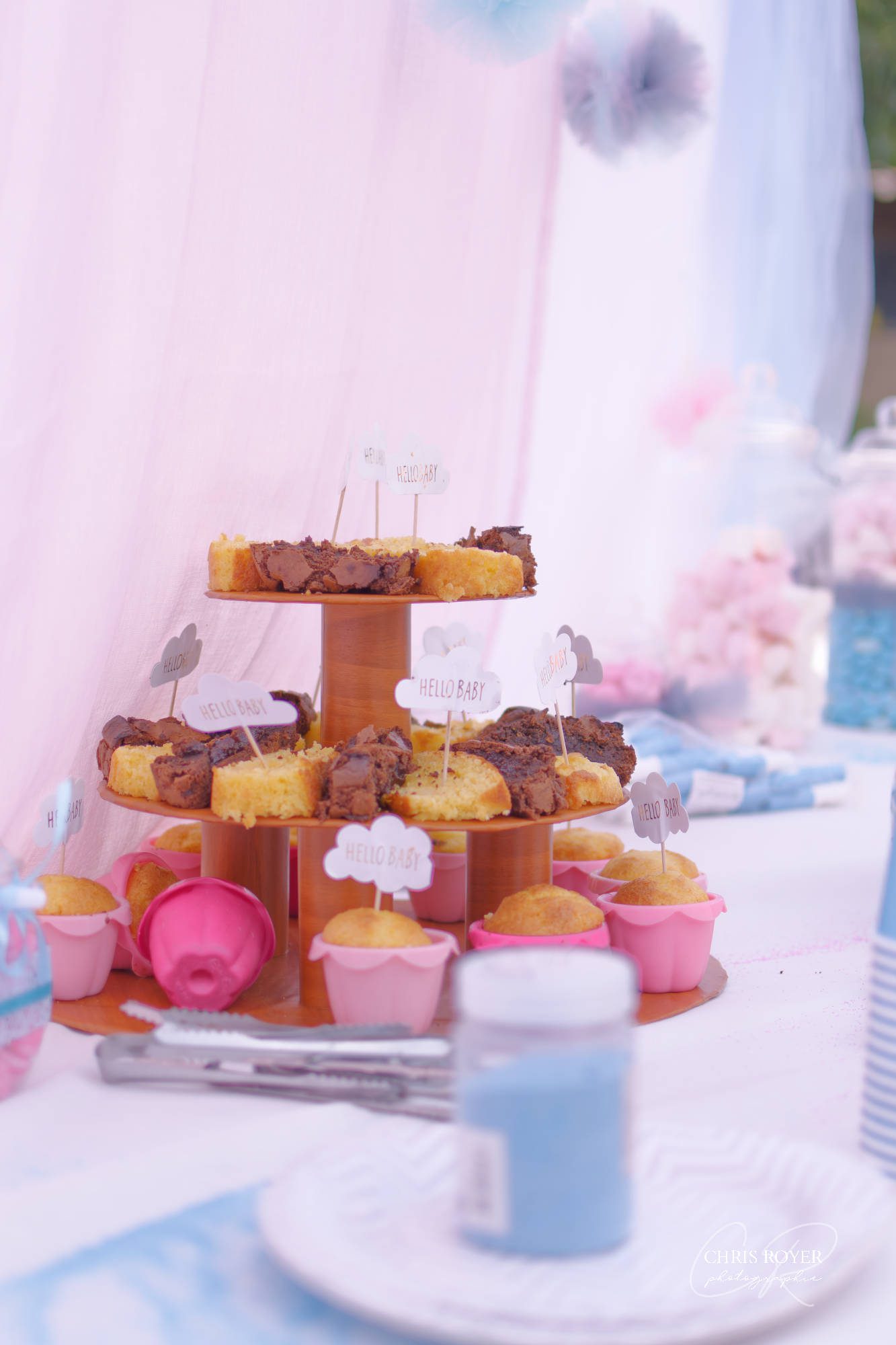 Table élégamment décorée pour une baby shower avec gâteaux, cadeaux et panneaux ‘Hello Baby'