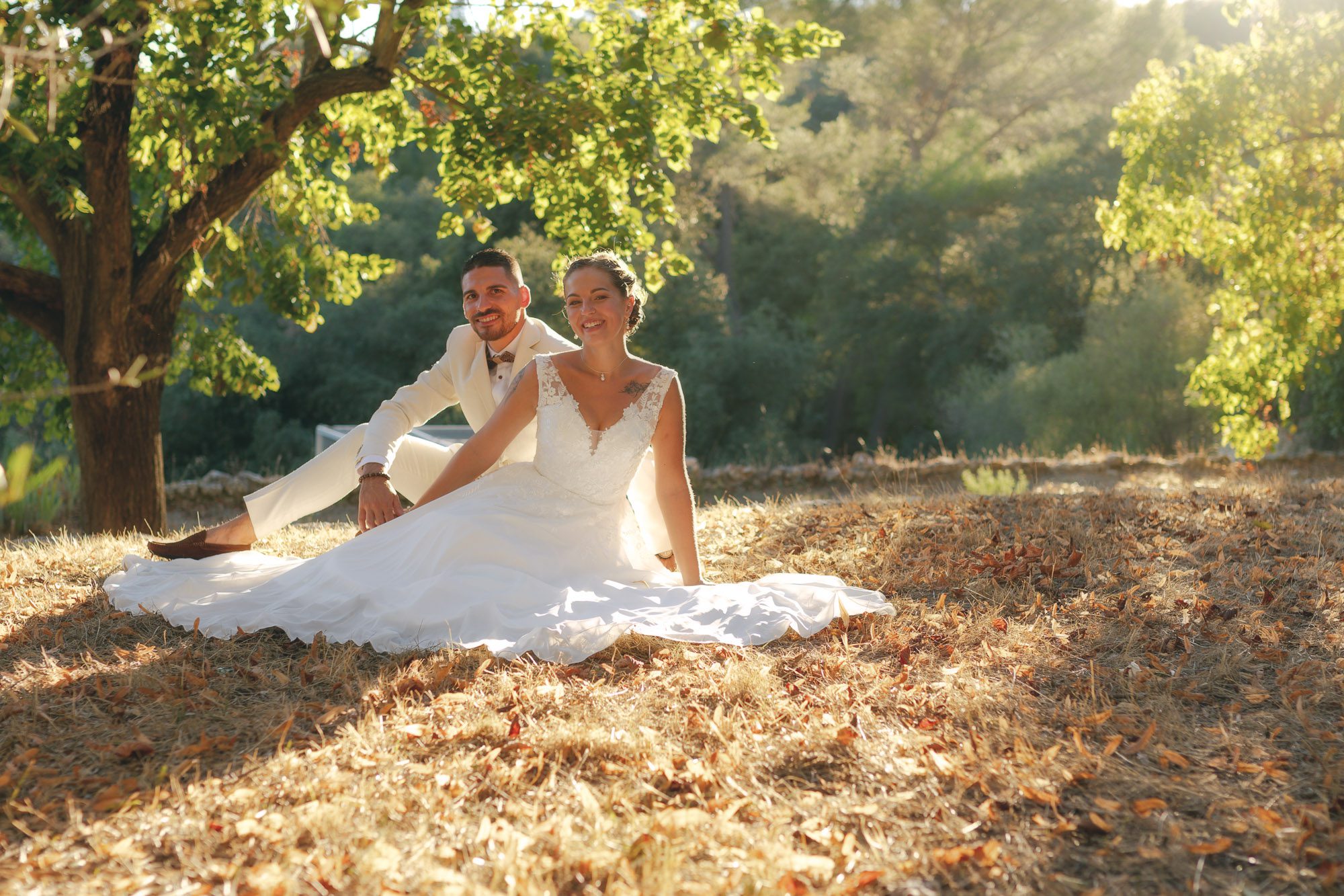 Le couple pose pour sa séance photo de mariage, baigné d’une lumière dorée et entouré du décor naturel du domaine.