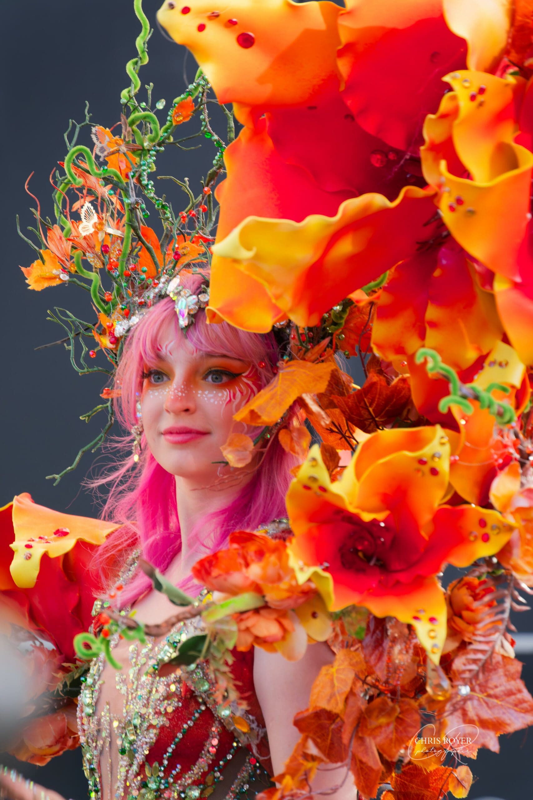 Artiste du Carnaval de Nice 2026 en costume coloré et festif représentant à la fois le feu et l'automne