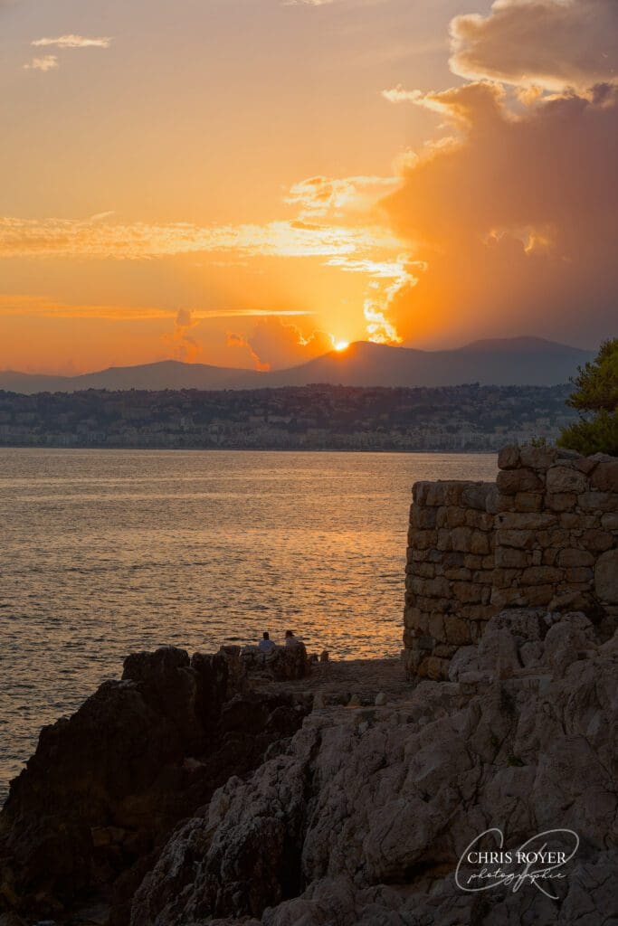 Photographe à Nice, coucher de soleil sur la mer à Coco Beach avec rochers et muret en pierre au premier plan, idéal pour séance photo portrait ou couple.