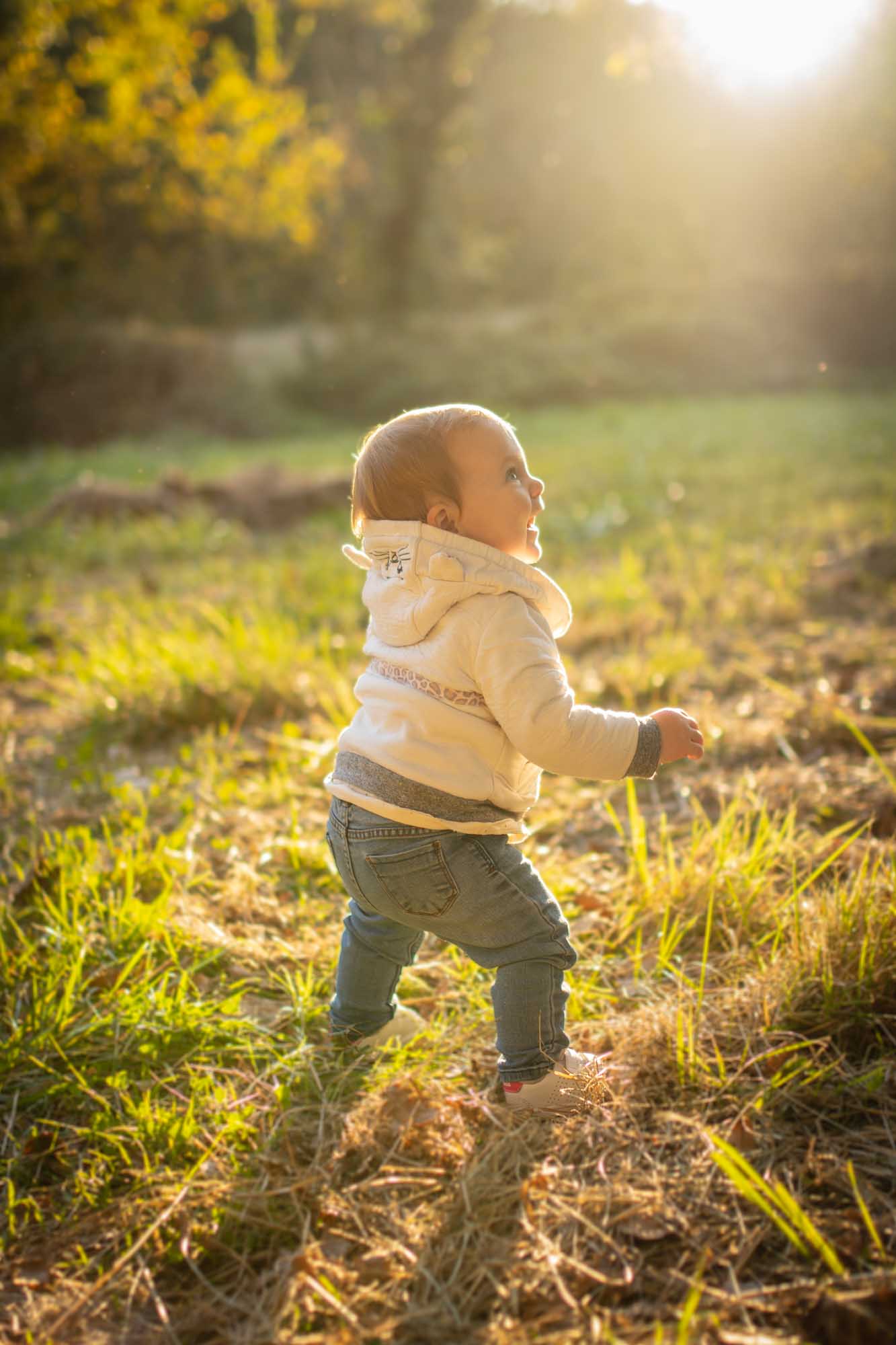 Un enfant marchant seul dans une prairie au golden hour au Parc de Vaugrenier, séance par un photographe famille Villeneuve-Loubet