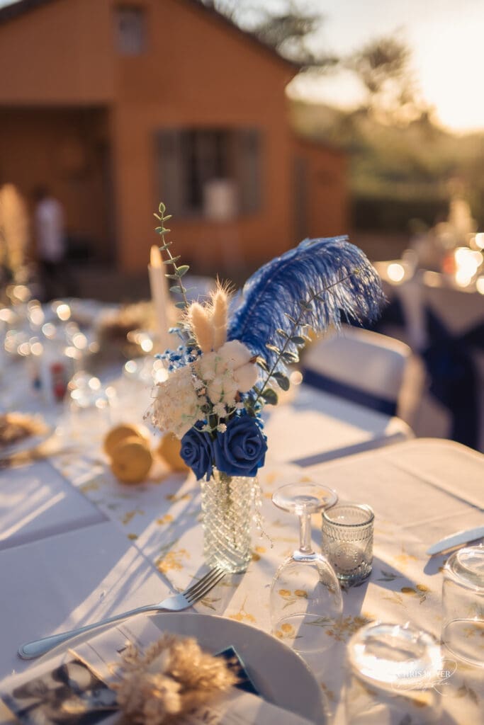 Composition florale bleue et blanche sur une table de mariage au Domaine du Viet Composition florale bleue et blanche sur une table de mariage au Domaine du Viet